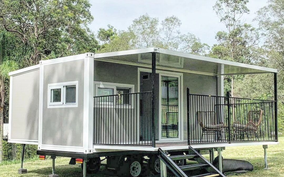 a small house on wheels in a grassy area
